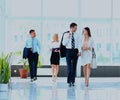 Businesspeople group walking at modern bright office interior. Royalty Free Stock Photo