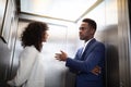 Businesspeople Having Conversation In Elevator Royalty Free Stock Photo