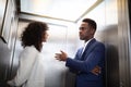 Businesspeople Having Conversation In Elevator