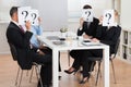 Businesspeople Hiding Faces Behind Question Mark Sign