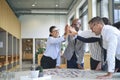 Businesspeople high fiving while solving a puzzle in an office Royalty Free Stock Photo