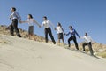 Businesspeople Holding Hands And Walking Uphill Royalty Free Stock Photo