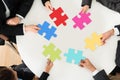 Businesspeople holding multi-colored jigsaw puzzle