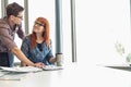 Businesspeople looking at each other while working at desk in creative office Royalty Free Stock Photo