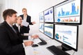 Businesspeople Looking At Financial Graphs On Multiple Computer Royalty Free Stock Photo