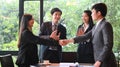Businesspeople are making confidence in others with handshakes while standing in meeting room.