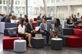 Businesspeople Meeting In Busy Lobby Of Modern Office Royalty Free Stock Photo