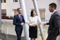 Businesspeople Meeting In Busy Lobby Of Modern Office Royalty Free Stock Photo