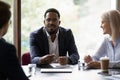 Businesspeople negotiating sit at desk focus on African businessman