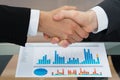 Businesspeople shaking hand in front of graph Royalty Free Stock Photo