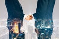 Businesspeople shaking hands on night city background. Teamwork, success and partnership concept. Double exposure Royalty Free Stock Photo