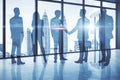 Businesspeople shaking hands in modern blue office interior with panoramic city view. Teamwork and success concep Royalty Free Stock Photo