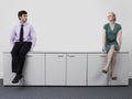 Businesspeople sitting on office cabinets