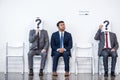 Businesspeople sitting in queue and waiting for interview, holding question marks in office Royalty Free Stock Photo