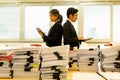 Businesspeople standing back-to-back with pile of paper work in foreground. Royalty Free Stock Photo