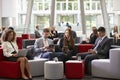 Businesspeople Using Digital Devices In Busy Office Lobby Royalty Free Stock Photo