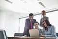 Businesspeople using laptop in conference room Royalty Free Stock Photo