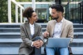 Businesspeople working with laptop sitting on building stair outside office centre background. Brainstorm, new idea, business, Royalty Free Stock Photo