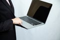 Businessperson in black suit using laptop computer on white background, concept of digital technology, remote work, online Royalty Free Stock Photo