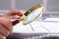 Businessperson Checking Invoice Through Magnifying Glass