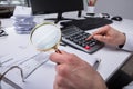 Businessperson Examining Invoice Through Magnifying Glass Royalty Free Stock Photo