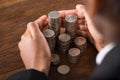 Businessperson Hand Protecting Pile Of Coins