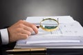 Businessperson Hands Analyzing Receipt With Magnifying Glass