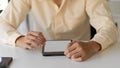 Businessperson hands working with mock-up tablet on simple office desk