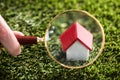 Businessperson Looking At House Model Through Magnifying Glass Royalty Free Stock Photo