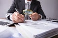 Businessperson Looking At Receipts Through Magnifying Glass Royalty Free Stock Photo