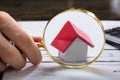 Businessperson With Magnifying Glass Zooming On House Model Royalty Free Stock Photo