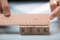 Businessperson Measuring Risk Blocks With Ruler