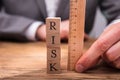 Businessperson Measuring Risk Wooden Blocks