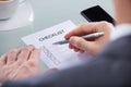 Businessperson with pen over checklist