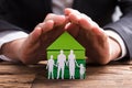 Businessperson Protecting House Model And Family Paper Cut Out Royalty Free Stock Photo
