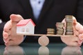 Businessperson Protecting House Model And Stacked Coins Royalty Free Stock Photo