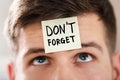 Sticky Note With Don`t Forget Text Stuck On Man`s Forehead