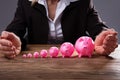 Businessperson`s Hand Protecting Piggybanks