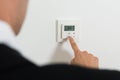 Businessperson Setting Temperature On Digital Thermostat Royalty Free Stock Photo