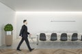 Businessperson in suit walking in wooden coworking meeting room interior with daylight, furniture and equipment. Design and ceo