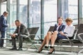 Businesss people sitting while waiting for boarding in airport Royalty Free Stock Photo