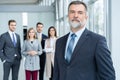 Businessteam in office, Happy Senior Businessman in His Office is standing in front of their team. Royalty Free Stock Photo