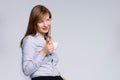 Businesswoman agent standing with coffee cup, looking side in distance. Empty space on gray background. Company leader taking