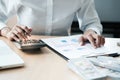 Businesswoman analyzing investment charts and pressing calculator buttons over documents. Accounting Concept Royalty Free Stock Photo