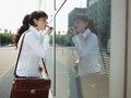 Businesswoman Applying Makeup Lipstick On Street Using Office Window Royalty Free Stock Photo