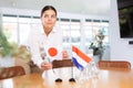 Businesswoman arranging the flags of Japan and Netherlands for presentation and negotiations