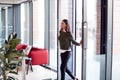 Businesswoman Arriving For Work At Office Walking Through Door