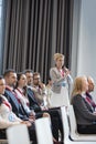 Businesswoman asking questions during seminar in convention center Royalty Free Stock Photo