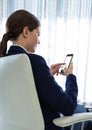Businesswoman Back Sitting in Chair with mobile phone by window Royalty Free Stock Photo
