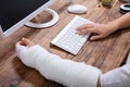 Businesswoman With Bandage Hand Using Keyboard Royalty Free Stock Photo